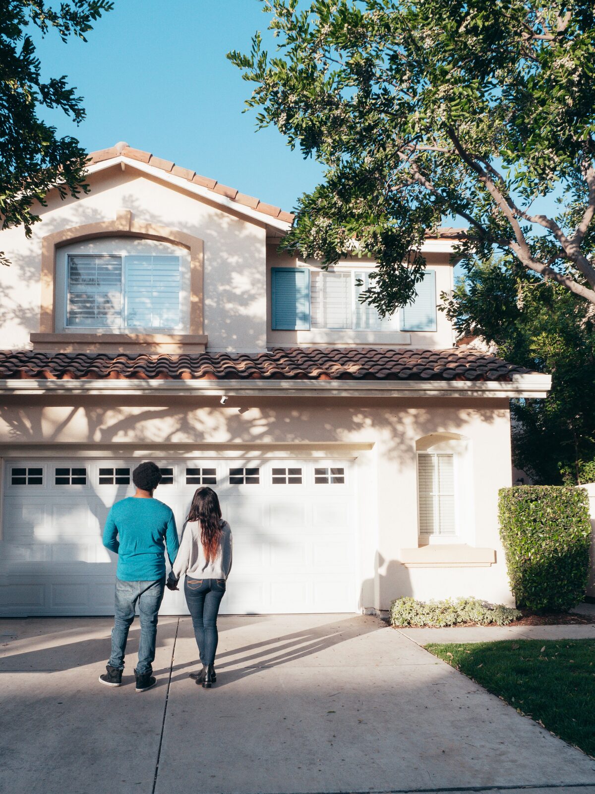 Happy homeowners standing in front of their house