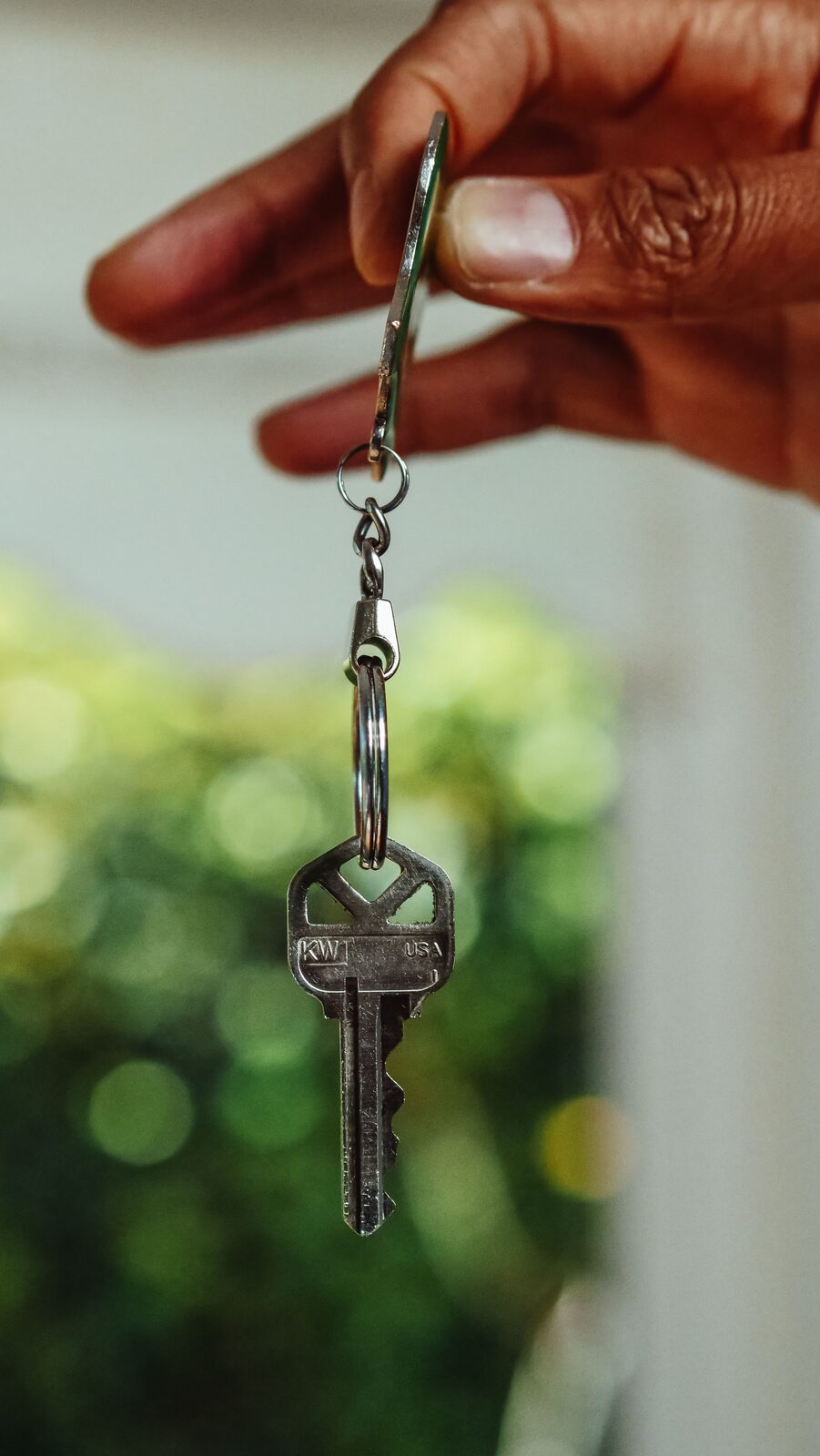 Hand holding a house key, symbolizing a loan takeover