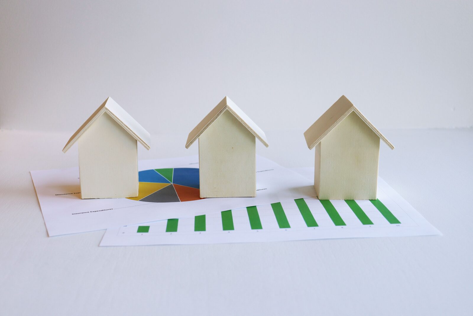 Miniature houses on top of investment analysis charts